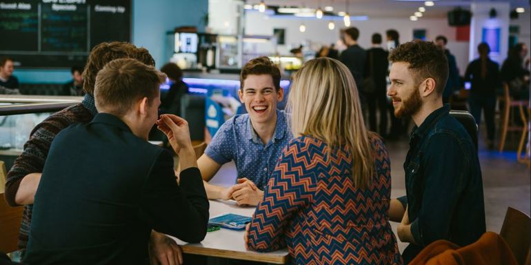 Cafe Bar - group of people smiling around a table in a cafe
