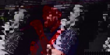 Huw Edwards on stage with a guitar and mic