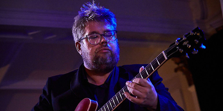 Nick Svarc playing a guitar